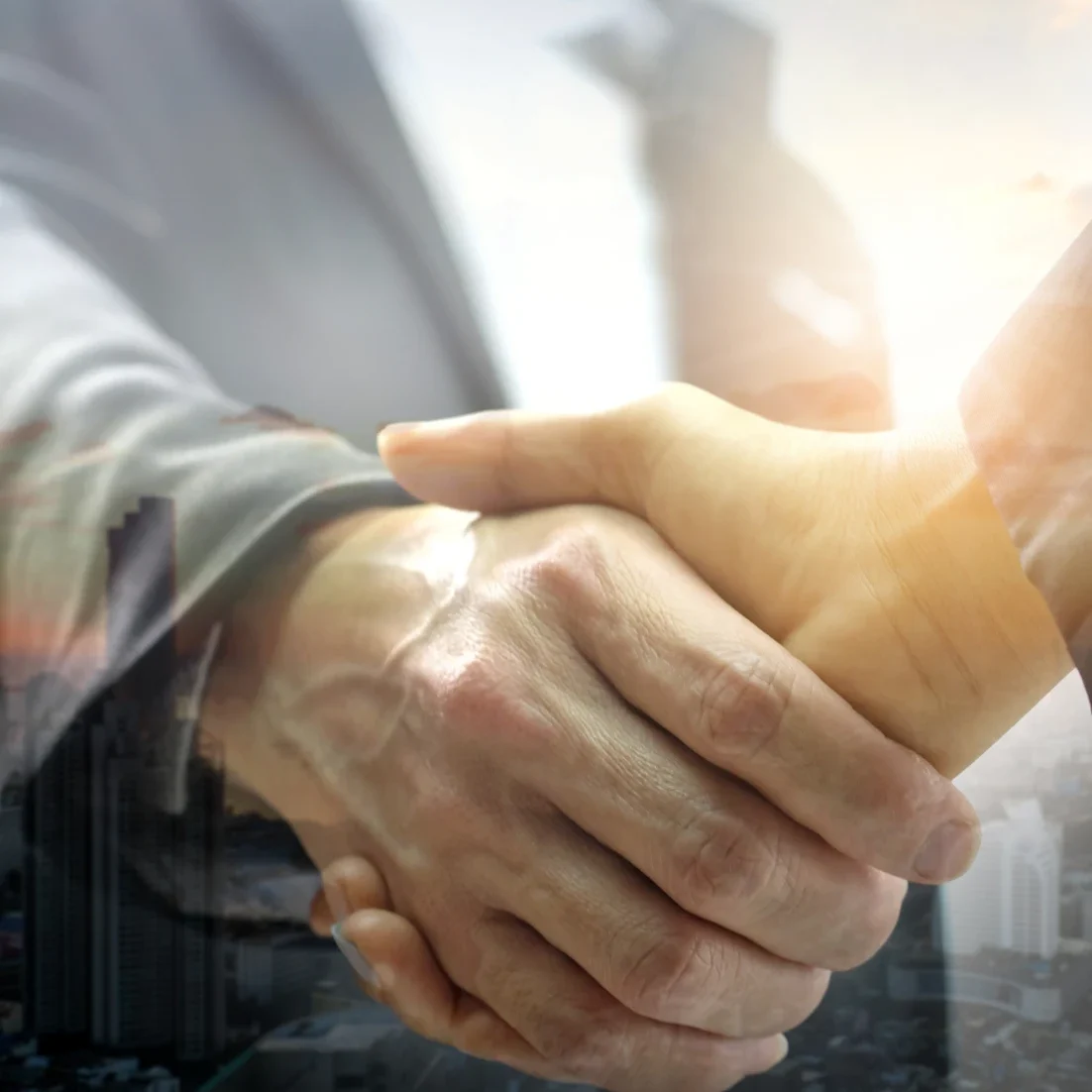 Handshake with city skyline in background.